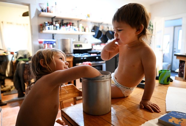 Dean Phillips, 4, and her younger brother Duke V, 3, sneak fingersfull of sugar from the sugar jar while waiting to get dressed early in the morning at Chico Basin Ranch on Feb. 2, 2024. Their parents Duke and Madi Phillips get up early every day to take on the tasks of ranching. (Photo by Helen H. Richardson/The Denver Post)