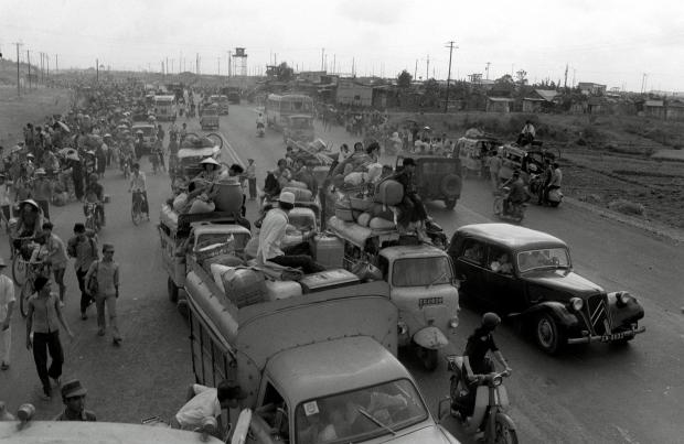 FILE- Refugees fleeing the advance of communist forces pour into Saigon April 28, 1975, arriving in jammed vehicles and on foot from rural districts north of the capital. (AP Photo/H. Hung, File)