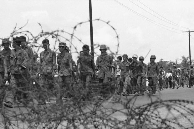 FILE- South Vietnamese troops and civilians retreat along Route 15 east of Saigon on Monday, April 28, 1975 past barbed wire they had erected to protect the area. But now they are fleeing the advancing communists. (AP Photo/Matt Franjola, File)